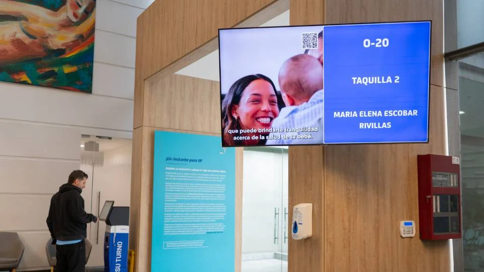 Queue calling screen combined with digital signage playing corporate video in a waiting room
